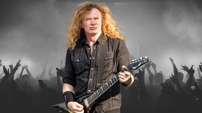 Dave Mustaine performing live on stage with his guitar in front of a cheering crowd